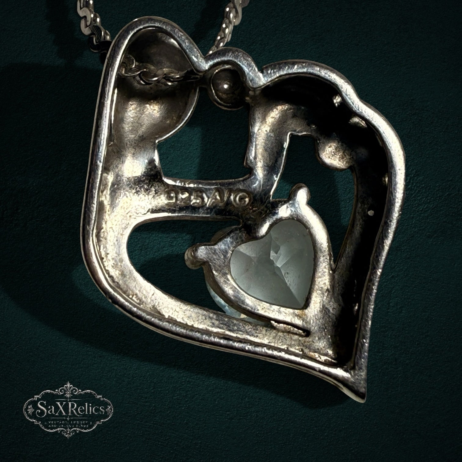 My Store sterling silver mother and child heart pendant necklace with a central light blue heart-cut gemstone.