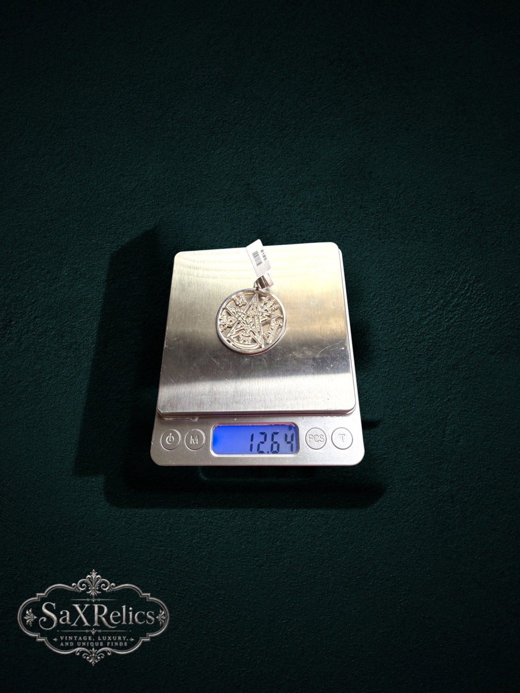 My Store sterling silver pentacle medallion pendant weighing 12.64 grams on a digital scale