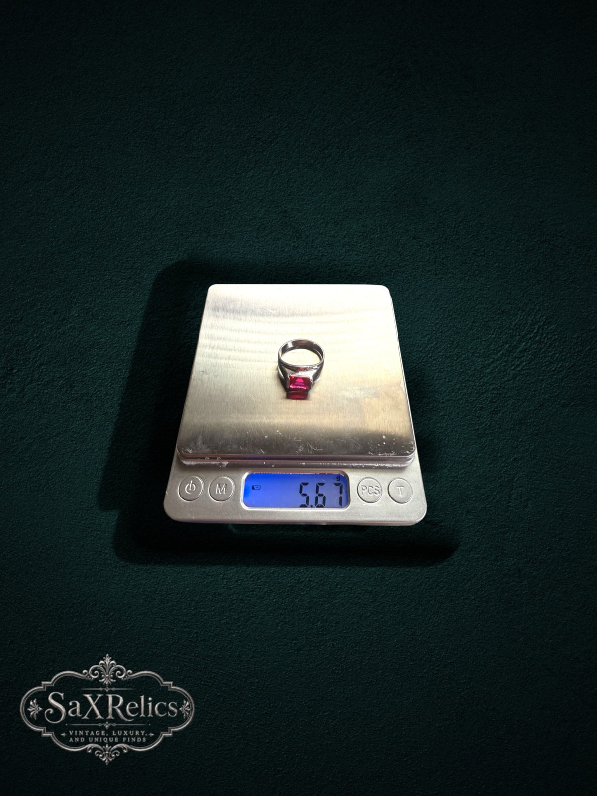 My Store sterling silver statement ring with a vibrant rectangular red gemstone resting on a digital scale