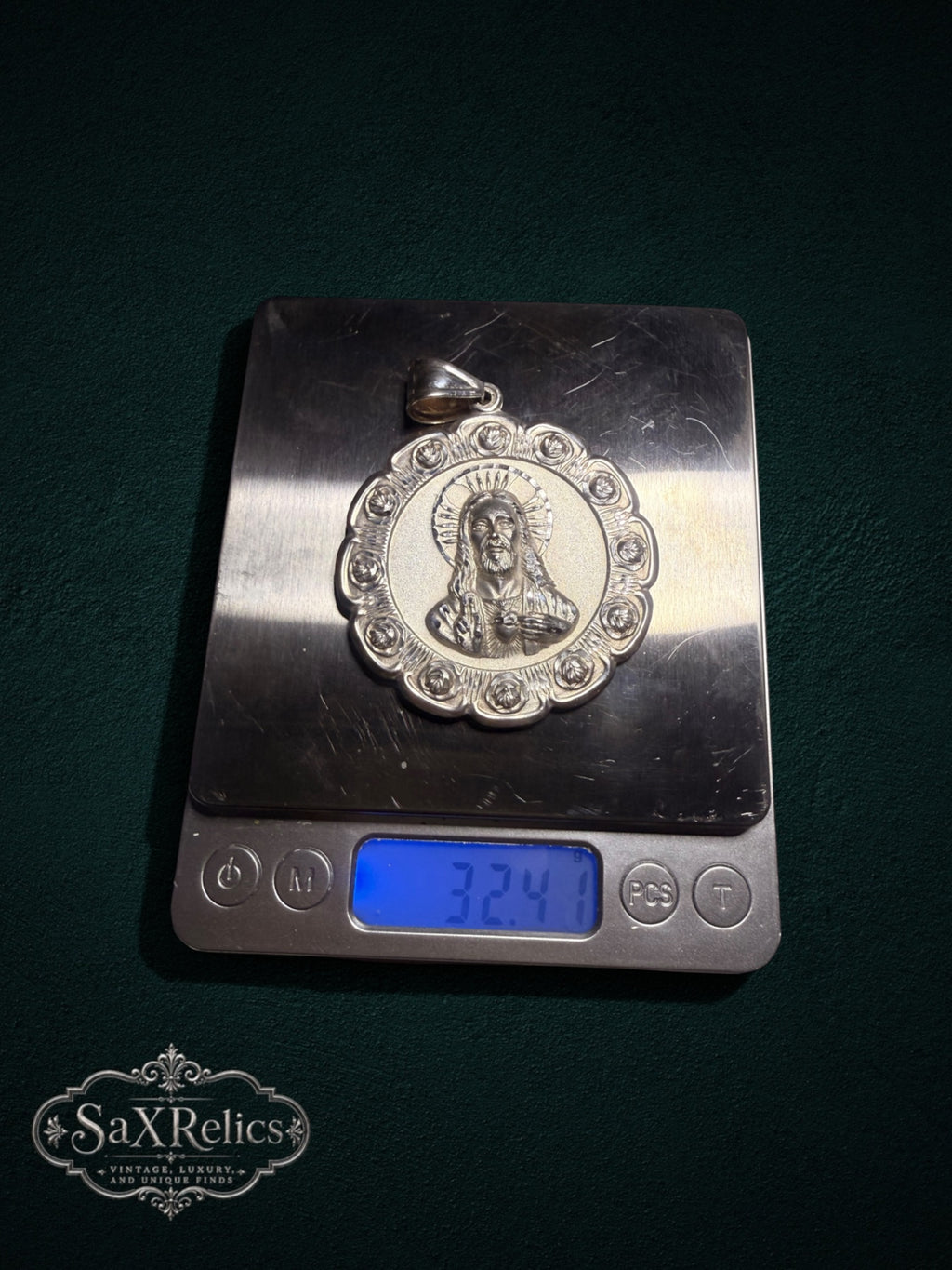 Sterling silver Sacred Heart of Jesus pendant with ornate rose border on a digital scale weighing 32.41 grams.