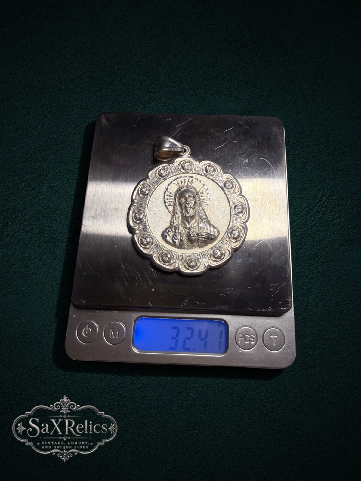 Sterling silver Sacred Heart of Jesus pendant with ornate rose border on a digital scale weighing 32.41 grams.