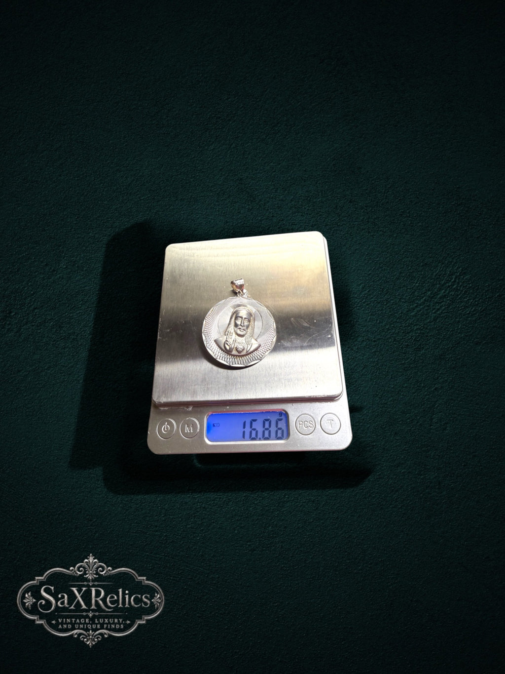 My Store sterling silver religious pendant featuring the Sacred Heart of Jesus on a digital scale weighing 16.86 grams.