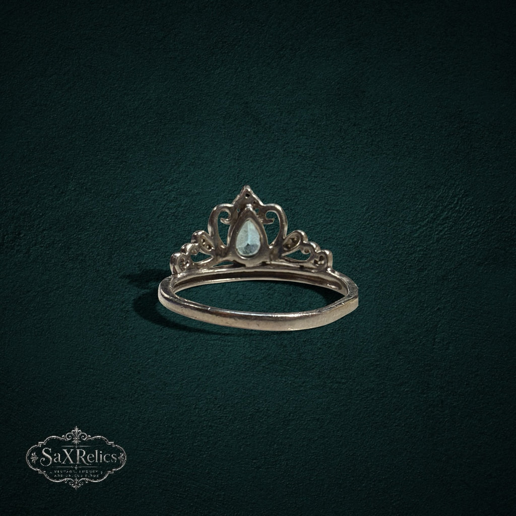 My Store sterling silver tiara ring featuring a pear-cut light blue gemstone and intricate crown-inspired filigree.