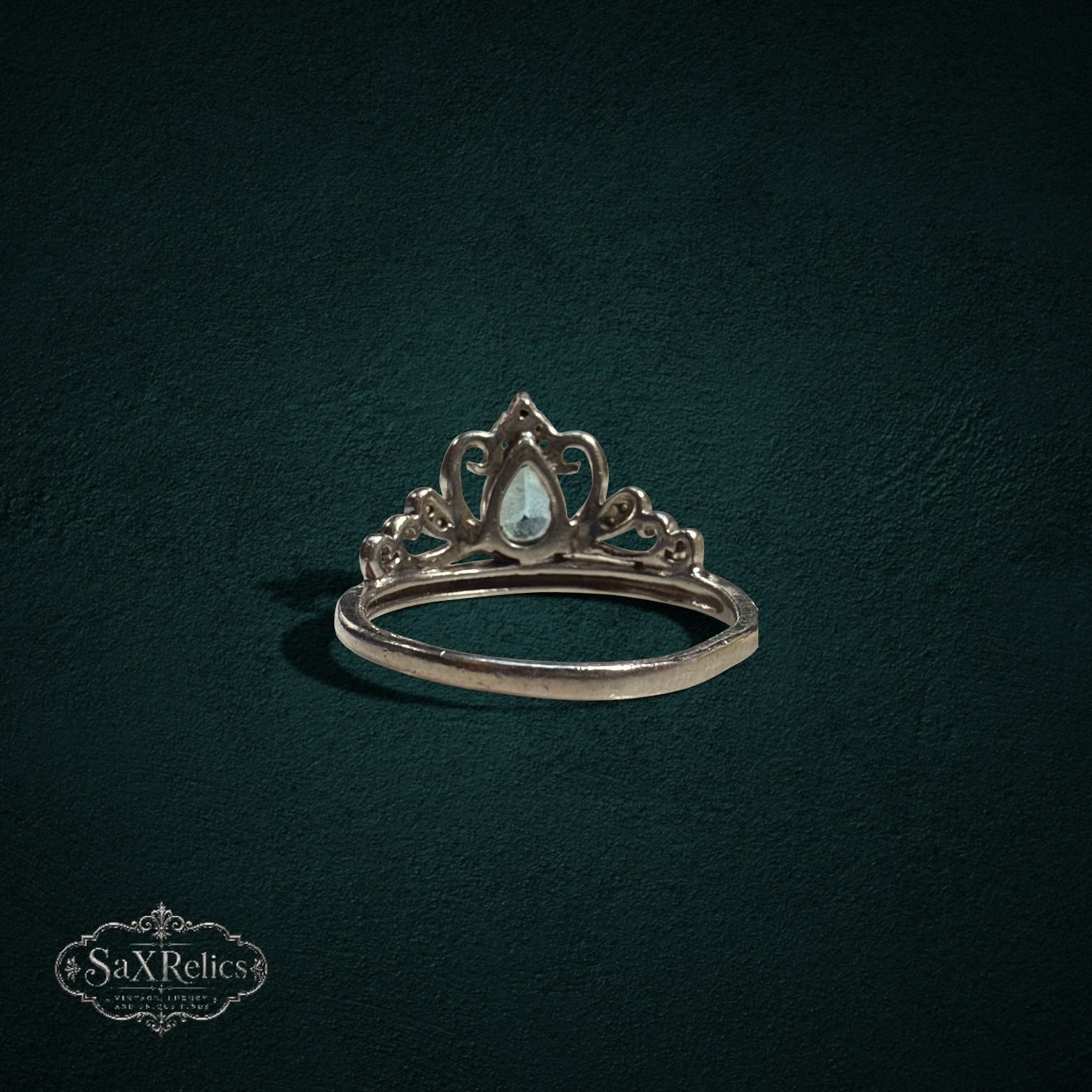 My Store sterling silver tiara ring featuring a pear-cut light blue gemstone and intricate crown-inspired filigree.