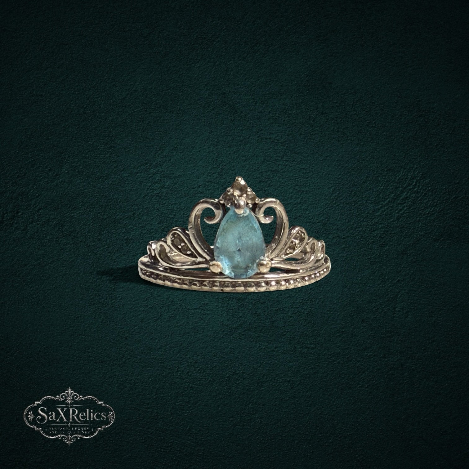 My Store sterling silver tiara ring featuring a pear-cut light blue gemstone with intricate filigree crown detailing.