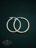 My Store SAXRelics textured hoop earrings with a diamond-cut finish and geometric pattern on a dark green background.