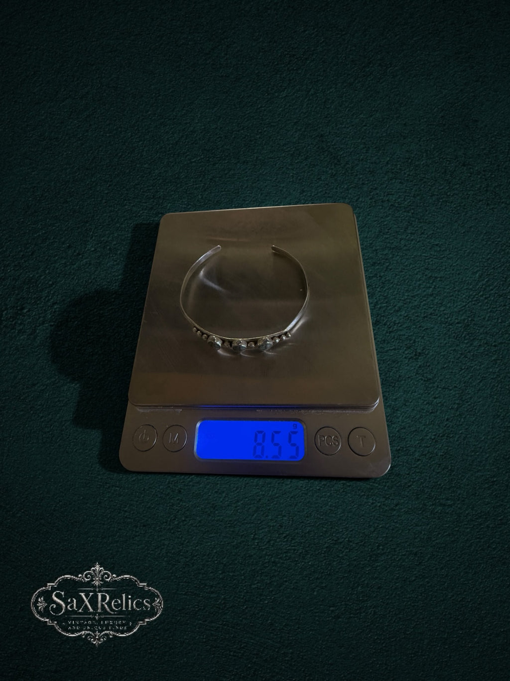 My Store sterling silver cuff bracelet with three turquoise stones on a digital scale showing 8.55 grams