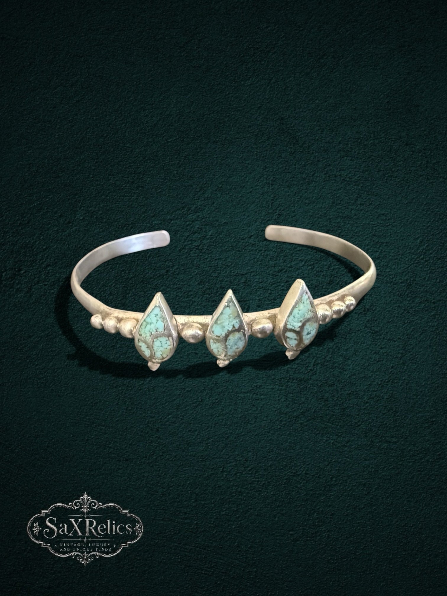 My Store sterling silver cuff bracelet featuring three teardrop turquoise stones with bead detailing on a dark background