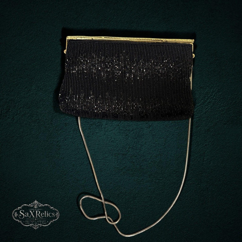 My Store vintage black beaded evening clutch with a gold-tone frame and delicate chain strap on a dark background.
