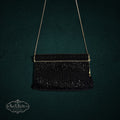 My Store vintage black beaded evening clutch with gold-tone chain strap against a dark textured background