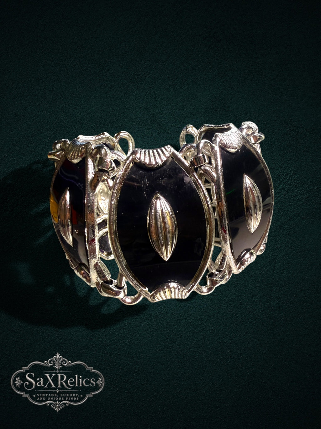 Vintage statement link bracelet featuring black enamel oval panels set in polished silver-tone metal links.