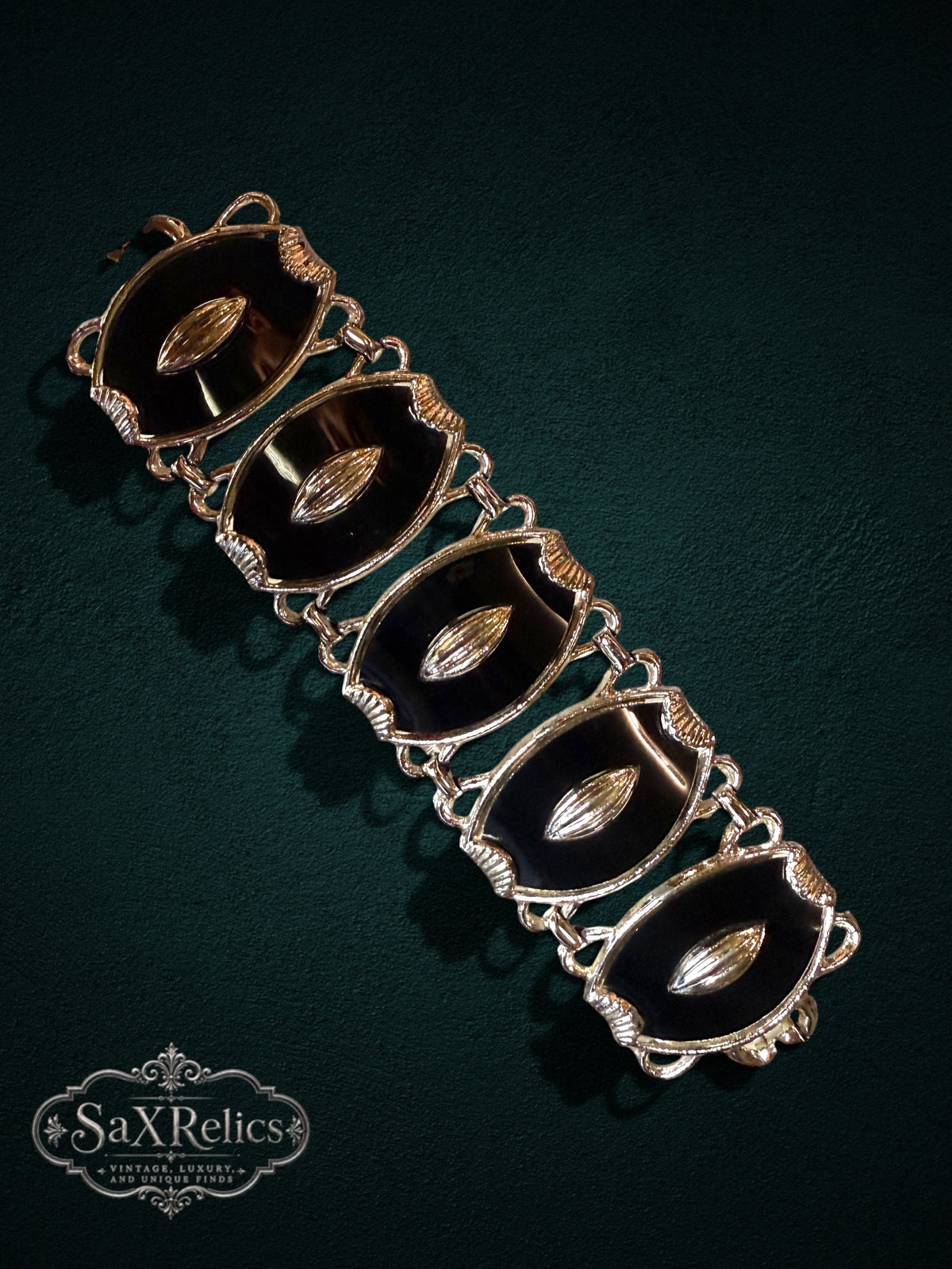 Vintage statement link bracelet featuring black enamel panels and polished silver-tone metal accents.