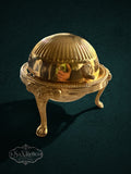 My Store vintage brass butter dish with a fluted domed lid and ornate lion-paw feet on a dark background.