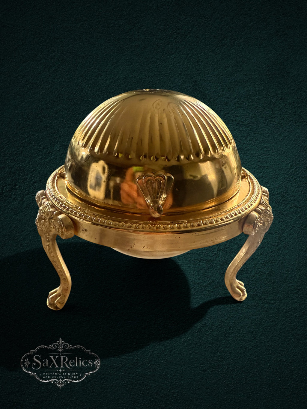 My Store vintage brass butter dish with a fluted dome lid and ornate lion-paw cabriole legs on a dark background.