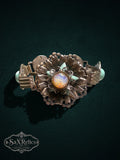 Vintage-inspired silver-tone link bracelet featuring an iridescent floral medallion and seafoam-green cabochons