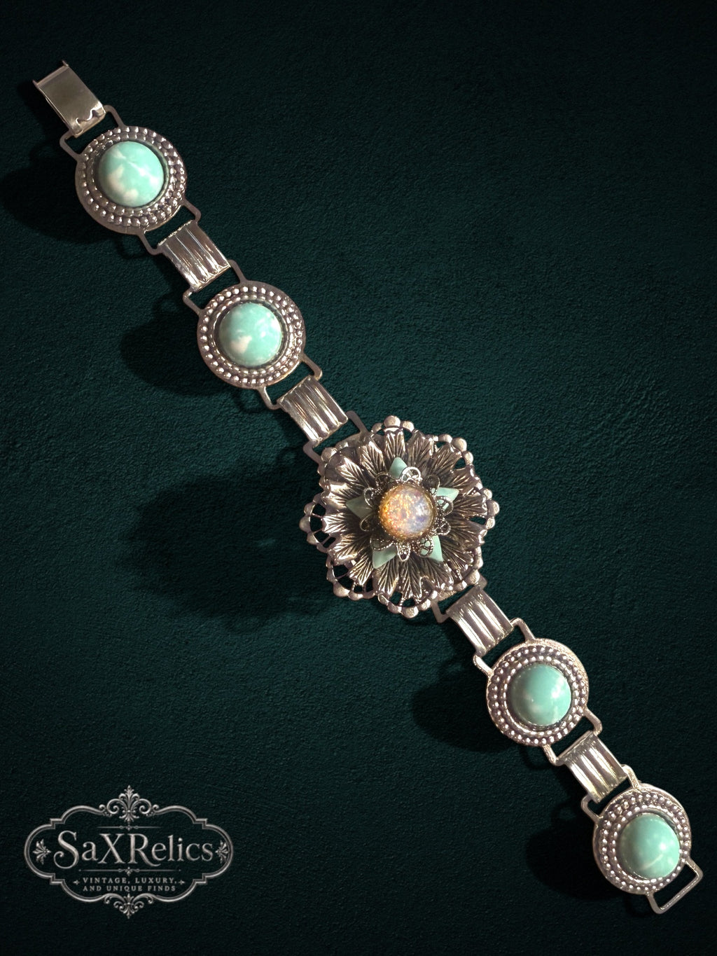 Vintage ornate link bracelet featuring a central iridescent medallion and seafoam-green cabochons in silver