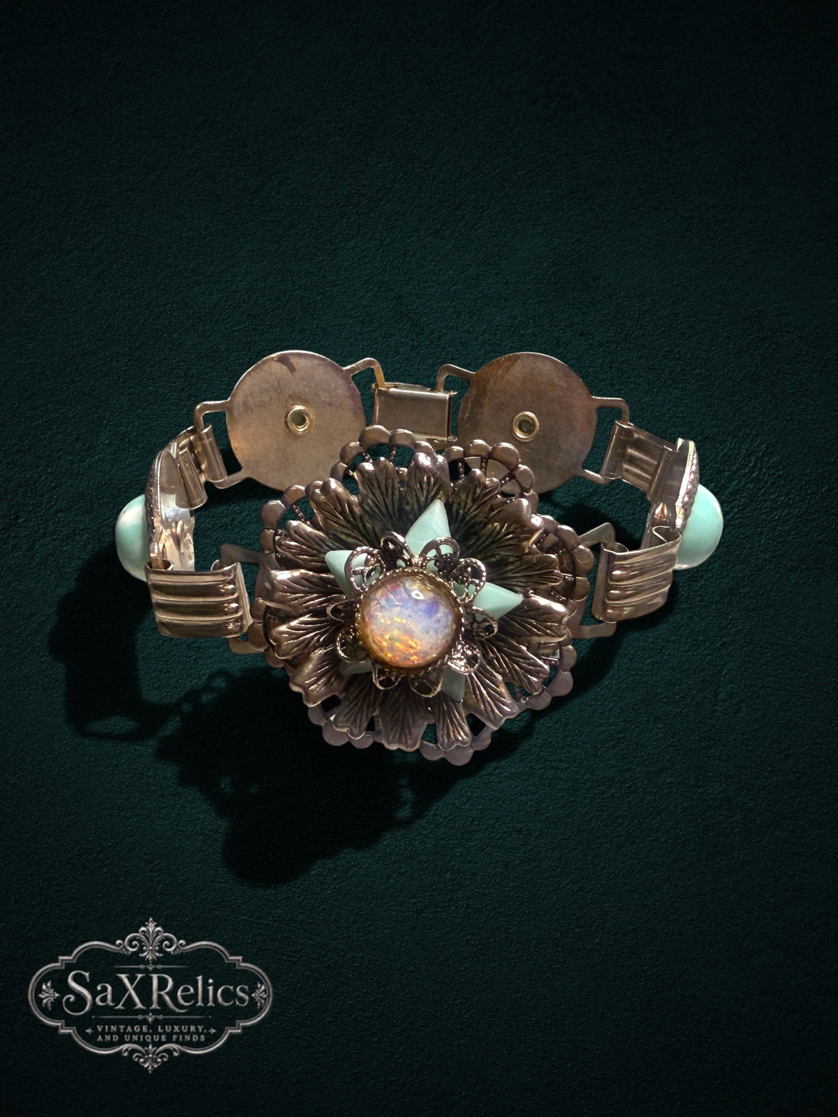 Vintage ornate floral link bracelet with iridescent cabochon and seafoam green accents in silver-tone metal.