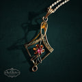 SaX Relics — Pétalo vintage 12K gold fill pendant, diamond-shaped frame around a floral motif with a pink stone.