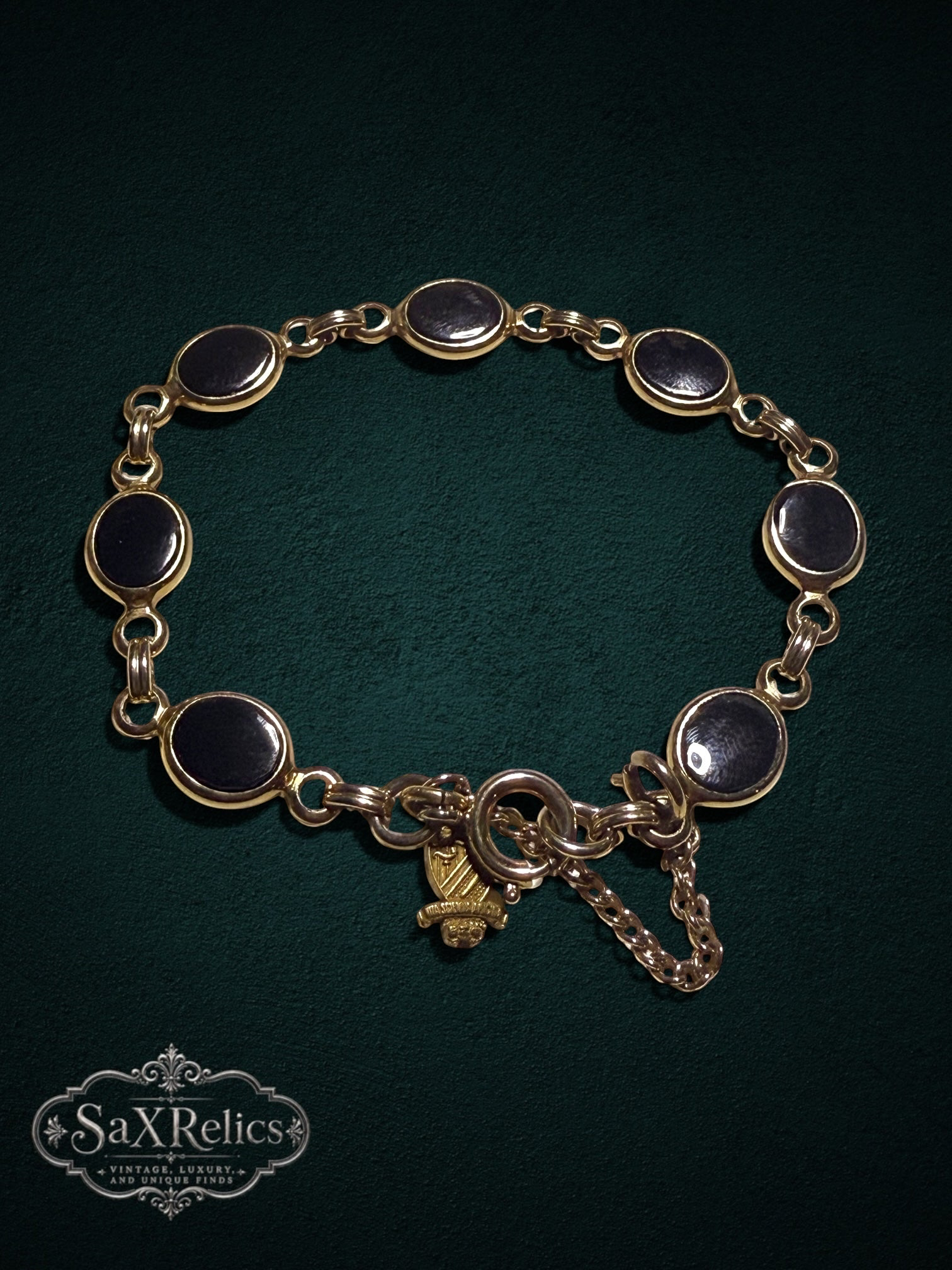 My Store vintage gold-tone bracelet with oval black cabochon links and a detailed heraldic crest charm.