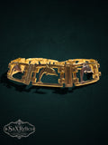 My Store vintage gold tone link bracelet featuring leaping dolphin motifs in rectangular frames on a dark background