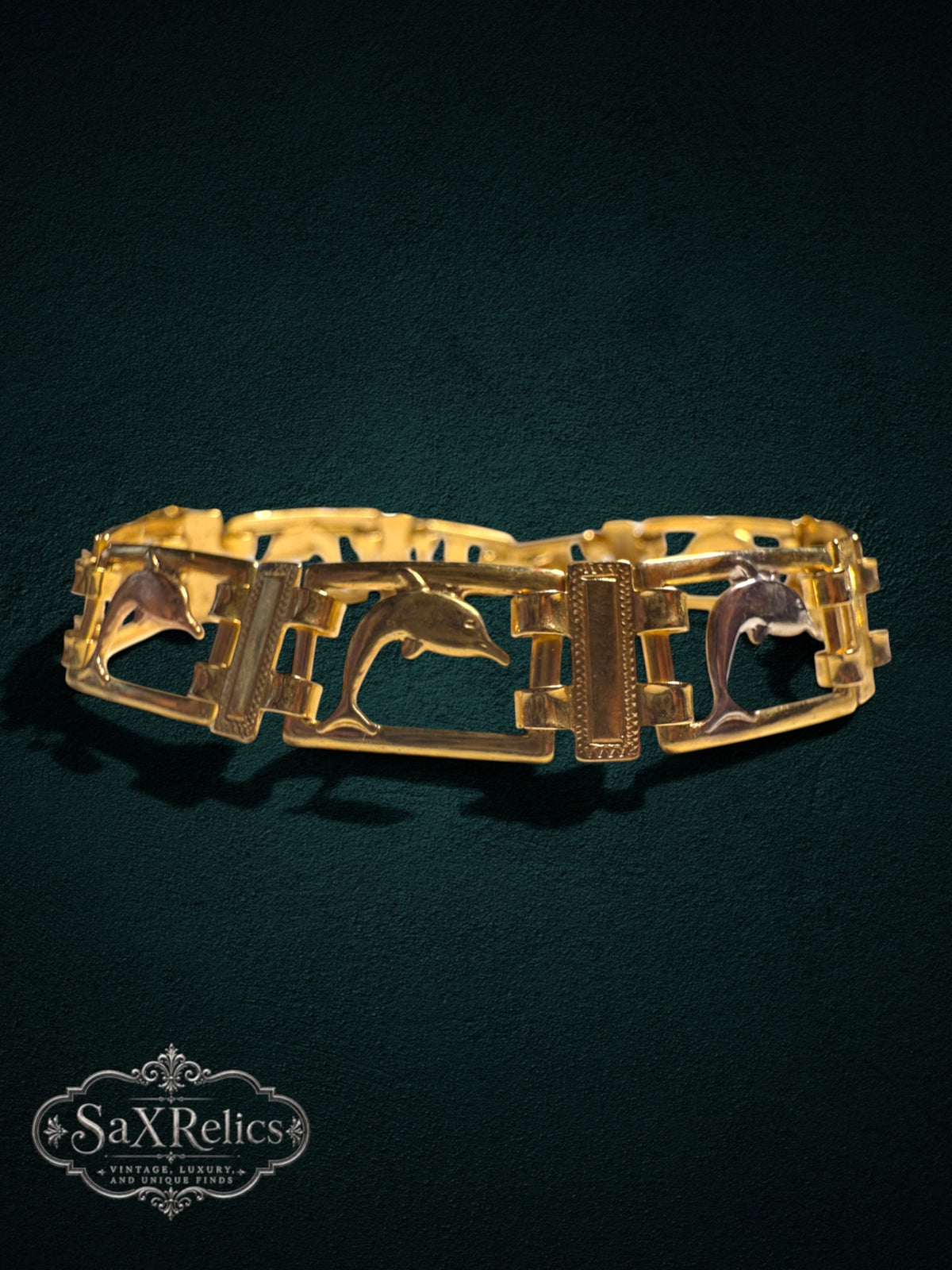 My Store vintage gold tone link bracelet featuring leaping dolphin motifs in rectangular frames on a dark background