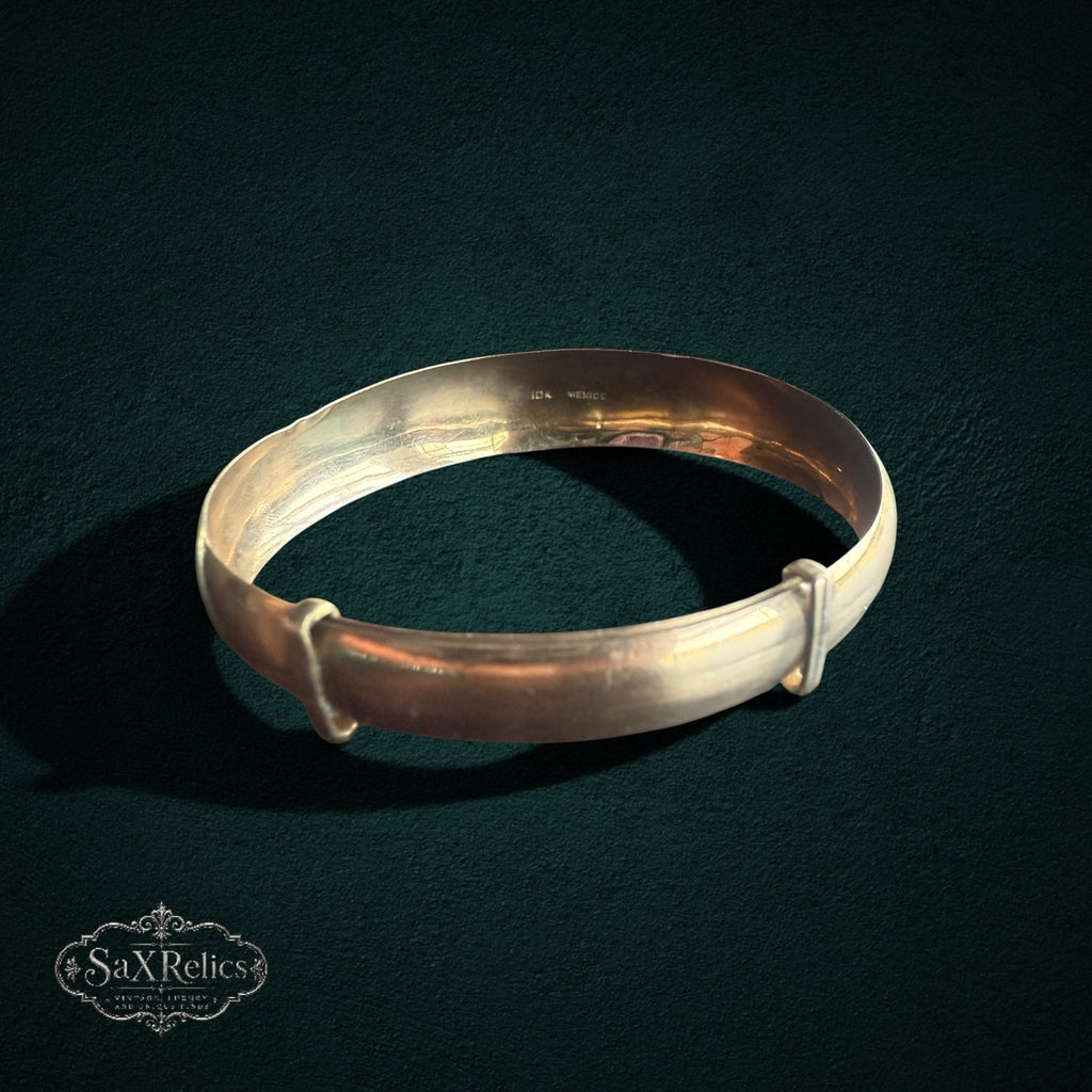 My Store vintage-inspired gold expandable bangle bracelet with a smooth, polished finish on a dark background.