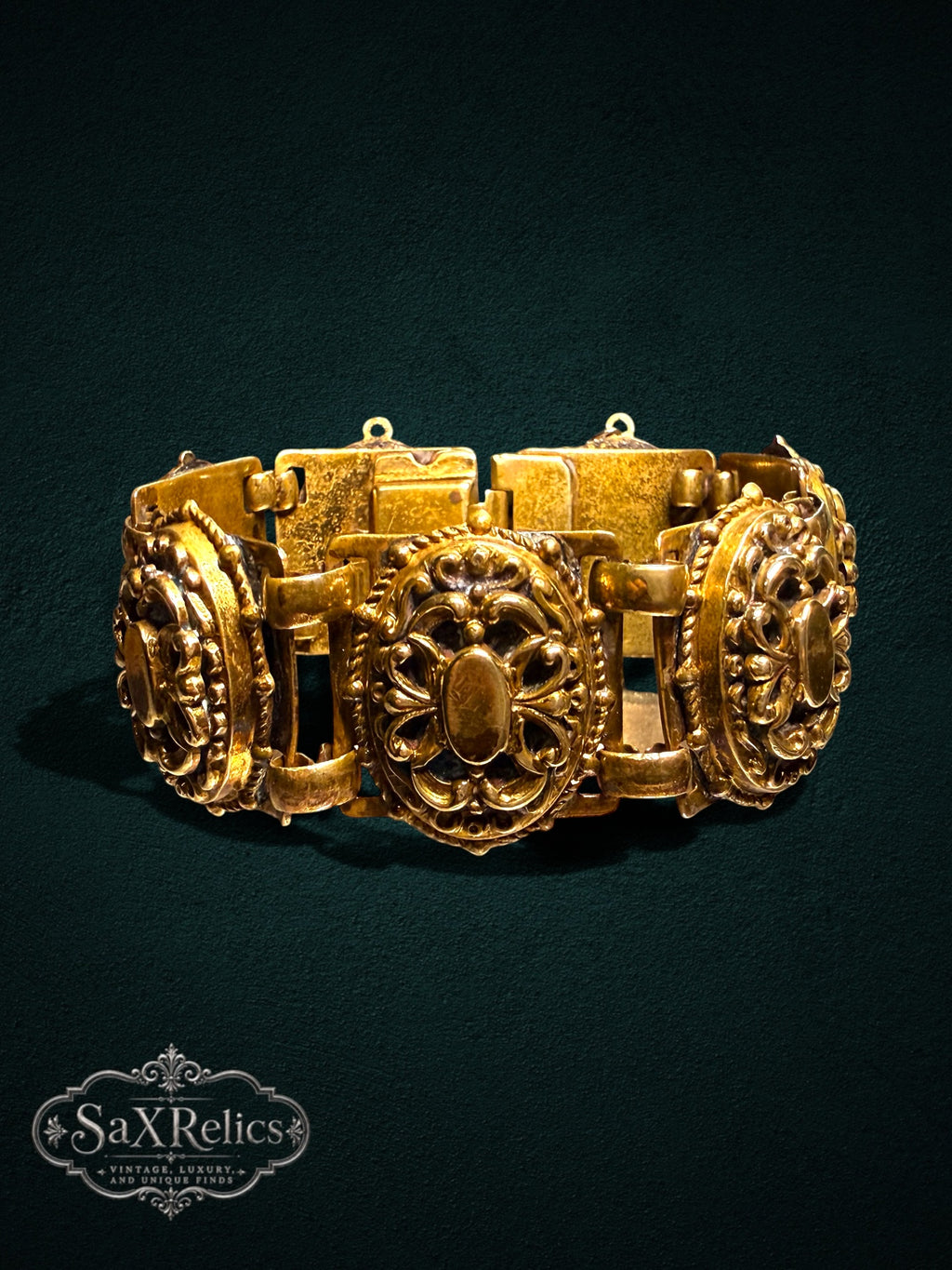 Ornate vintage-style gold-tone link bracelet featuring intricate filigree and scrollwork patterns.