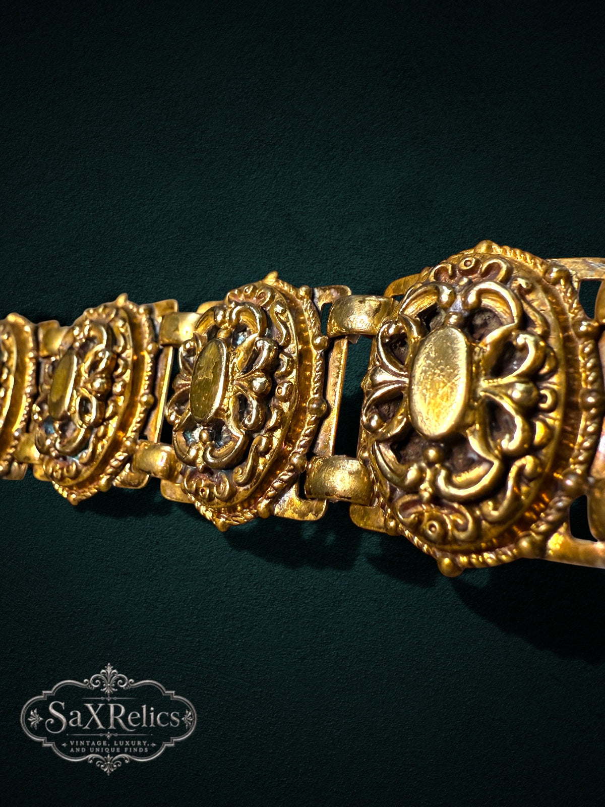 Ornate vintage-style gold-tone link bracelet featuring intricate filigree and scrollwork patterns.