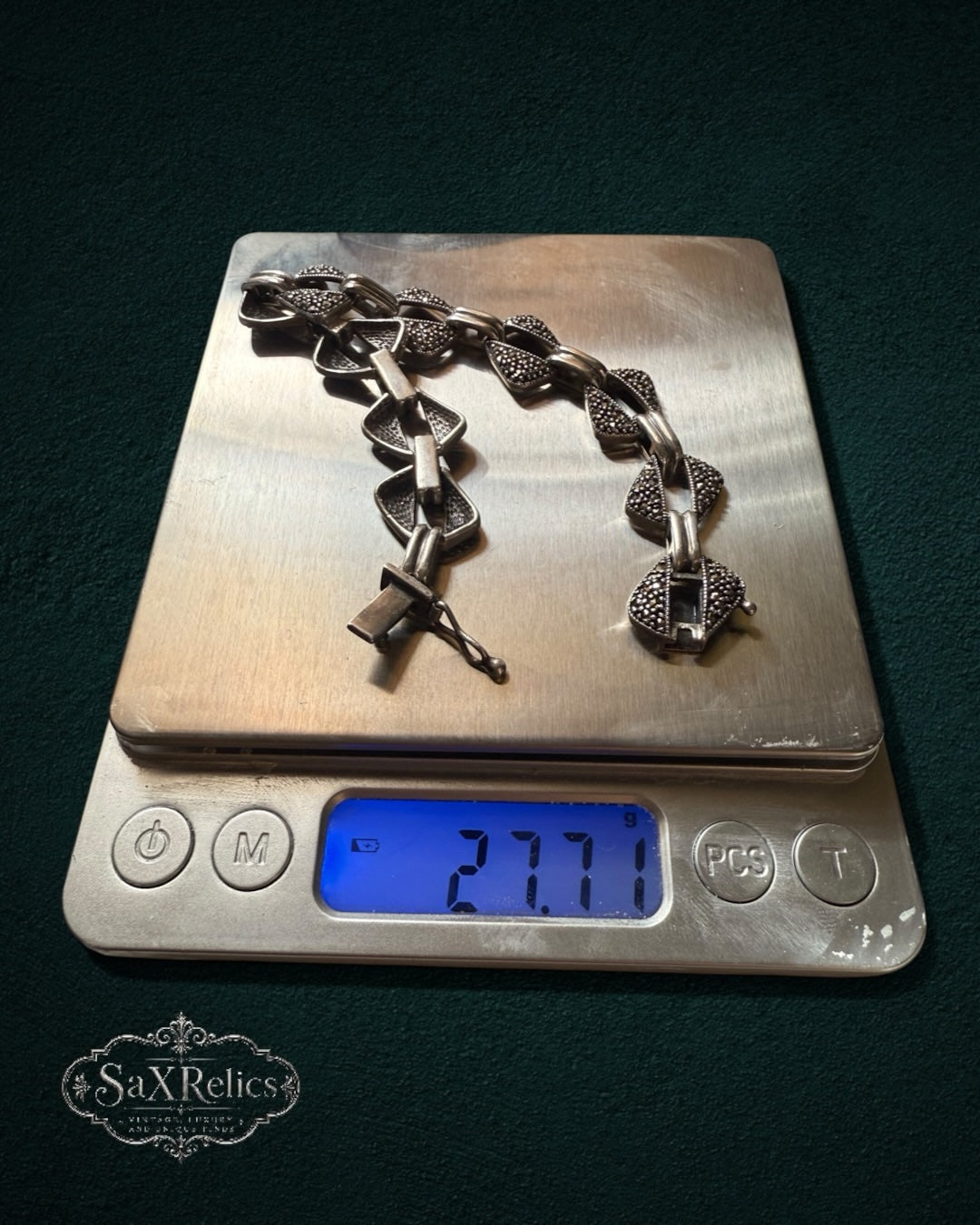 My Store vintage sterling silver bracelet with geometric triangular links and pavé-set marcasite stones on a scale.