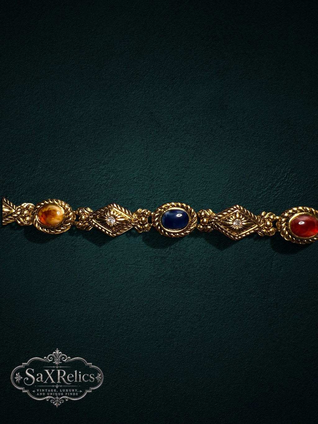 Vintage-inspired gold-tone link bracelet featuring multi-colored cabochon stones and crystal accents.