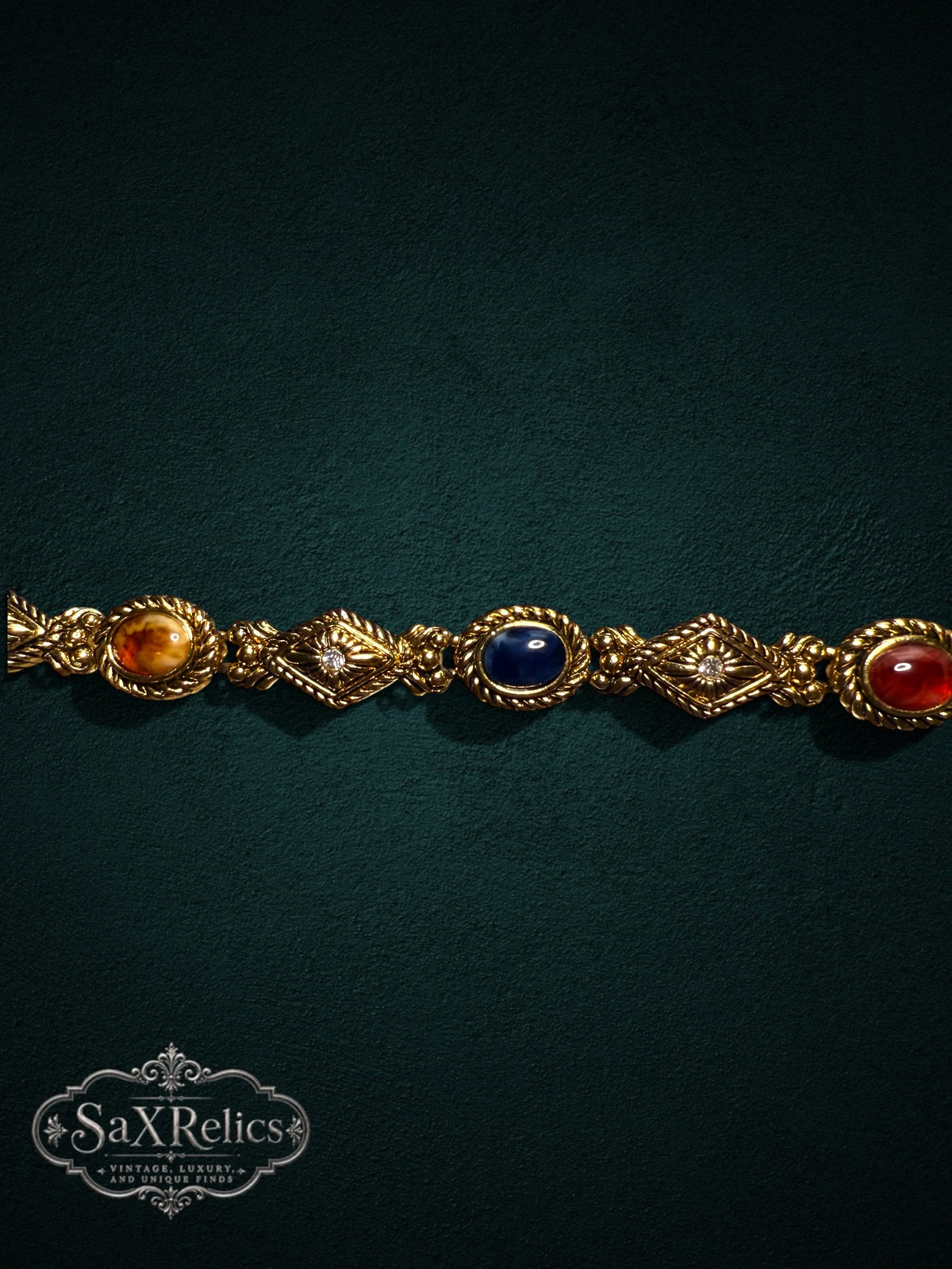 Vintage-inspired gold-tone link bracelet featuring multi-colored cabochon stones and crystal accents.