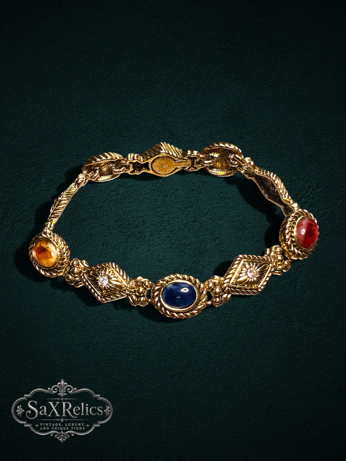 Vintage gold-tone link bracelet featuring multi-colored cabochon stones and crystal-accented diamond links.