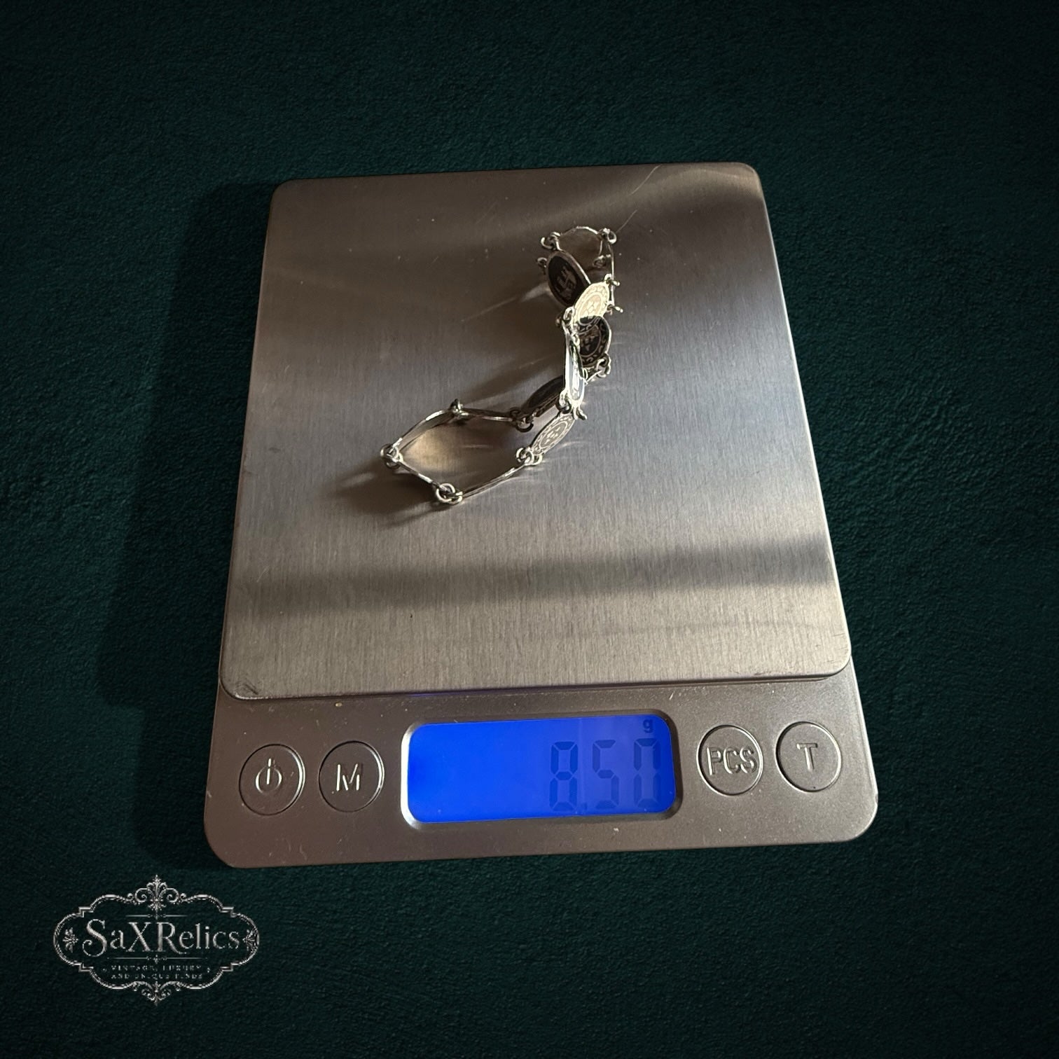 SaX Relics — Azabache Siam niello sterling silver bracelet on a digital scale at 8.50 grams.