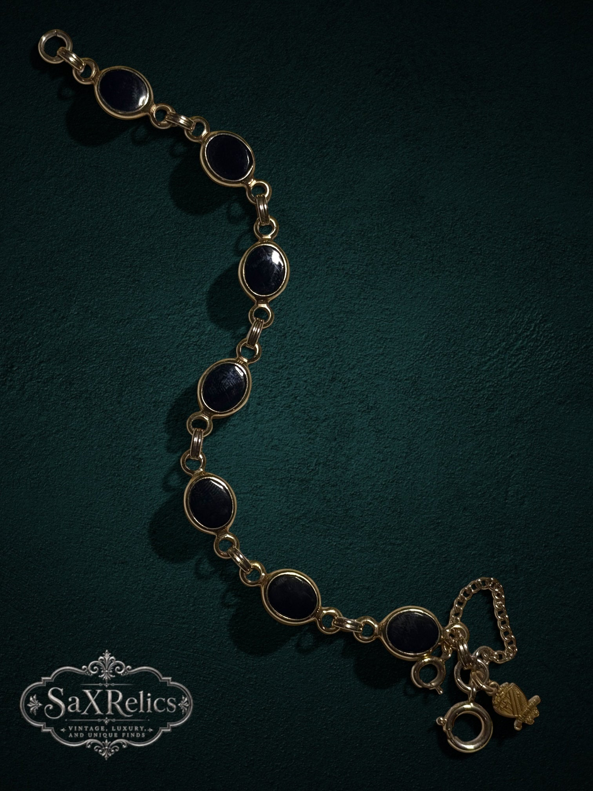 My Store vintage-inspired gold-tone bracelet featuring oval black cabochon links and a detailed heraldic charm.