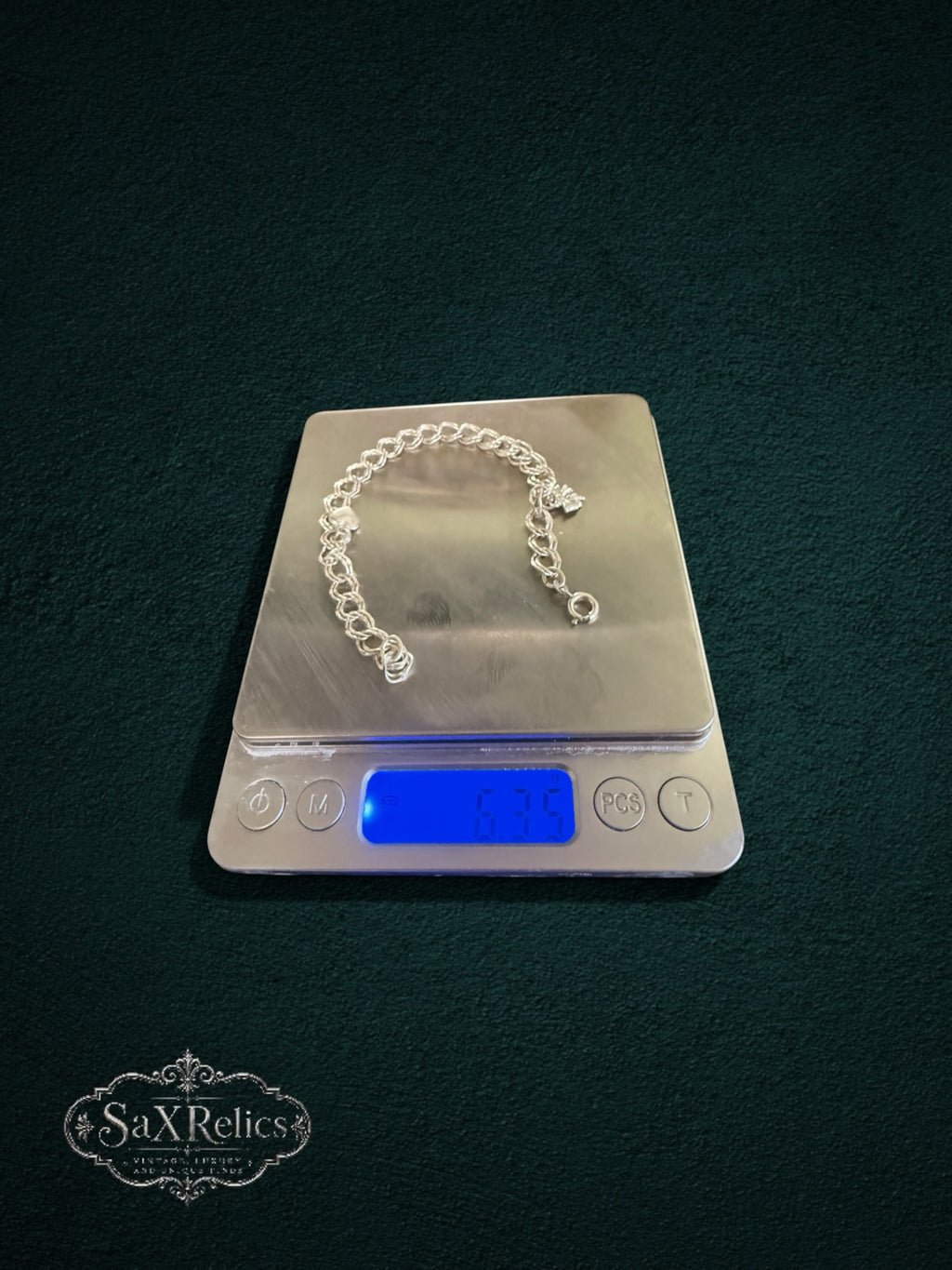 My Store SAXRelics vintage-inspired silver-tone charm bracelet with heart and floral charms on a digital scale