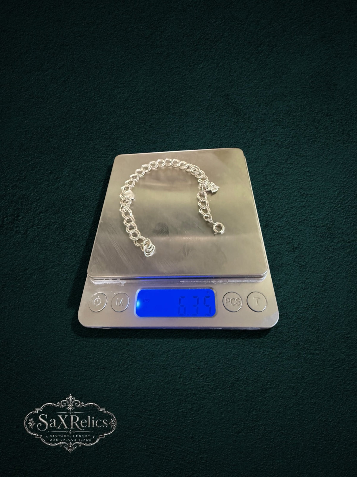 My Store SAXRelics vintage-inspired silver-tone charm bracelet with heart and floral charms on a digital scale