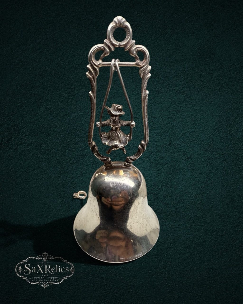 My Store vintage silver-plated table bell featuring a child on a swing inside an ornate scroll-work frame.