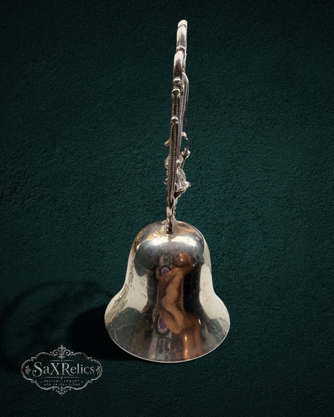 My Store vintage silver-plated table bell featuring a child on a swing within an ornate scroll-work frame.