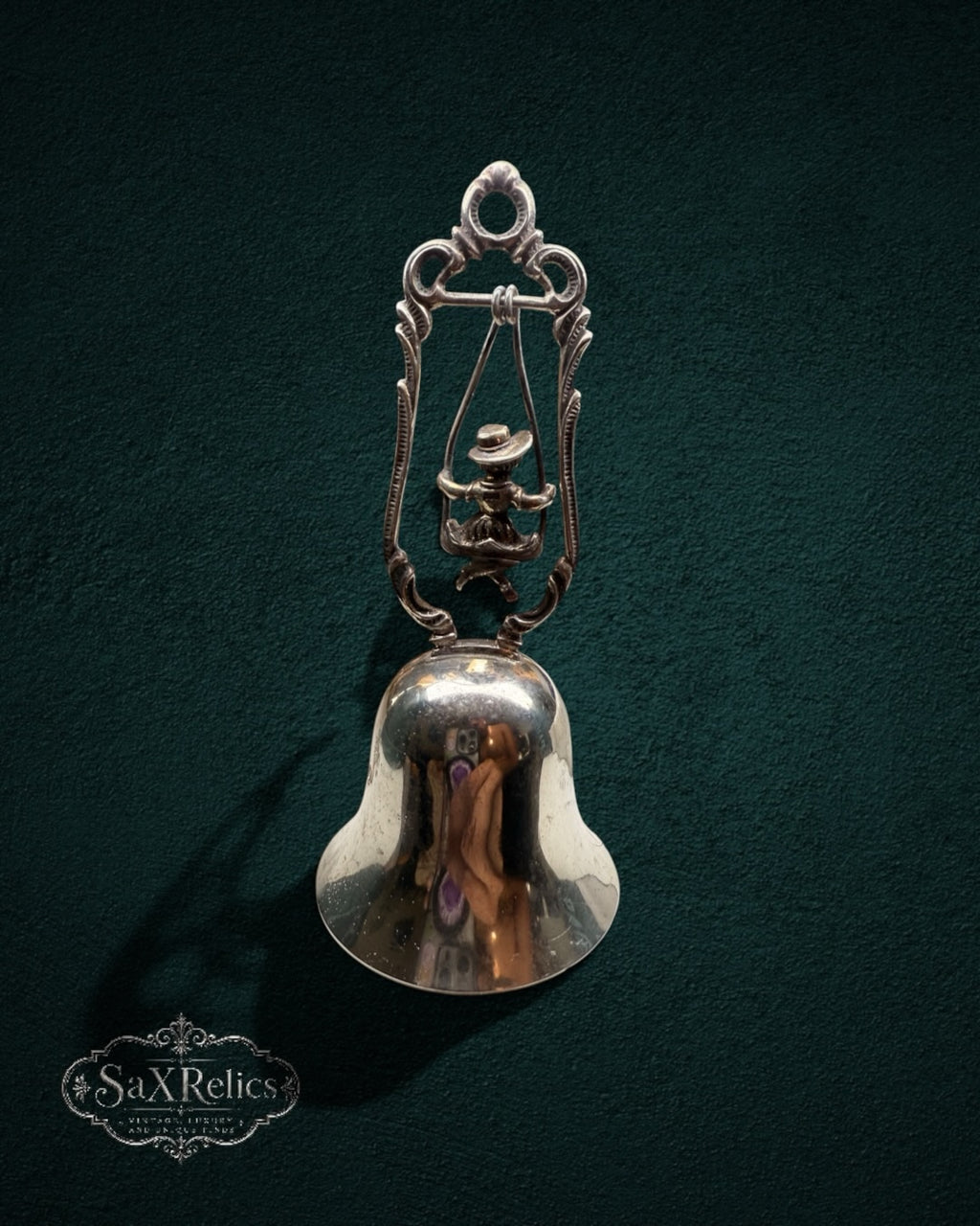 My Store vintage silver-plated table bell featuring a child on a swing within an ornate scroll-work frame