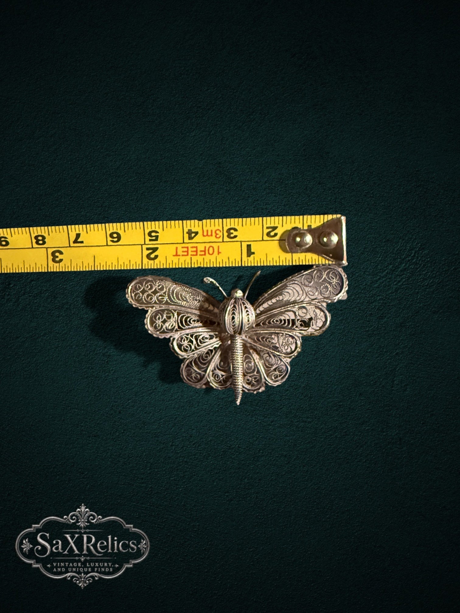 My Store vintage silver filigree butterfly brooch with intricate wirework, shown with a measuring tape for scale.