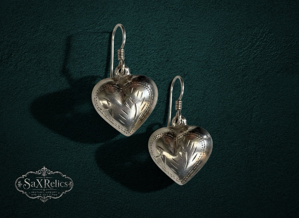 My Store vintage-inspired silver heart drop earrings with delicate etched floral detailing on a dark green background