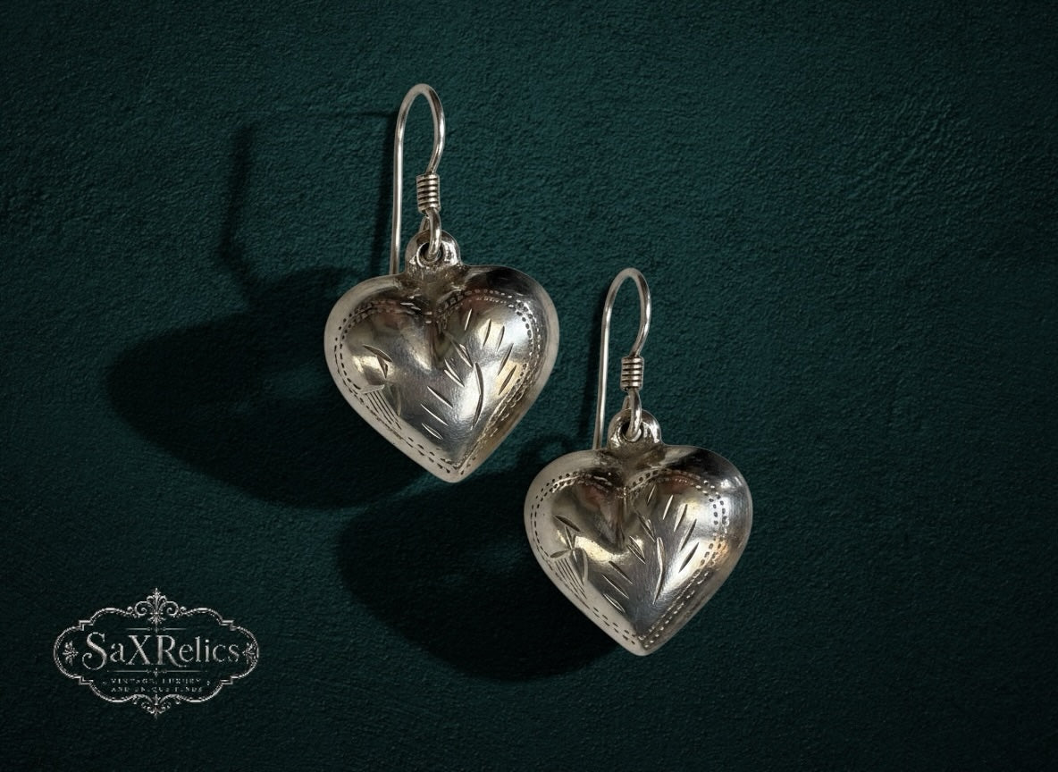 My Store vintage-inspired silver heart drop earrings with delicate etched floral detailing on a dark green background