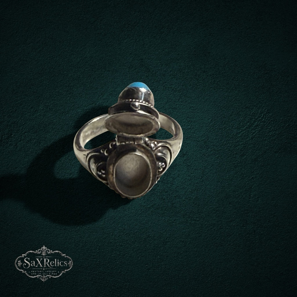 My Store vintage style sterling silver poison ring with an open hinged turquoise lid and intricate scrollwork