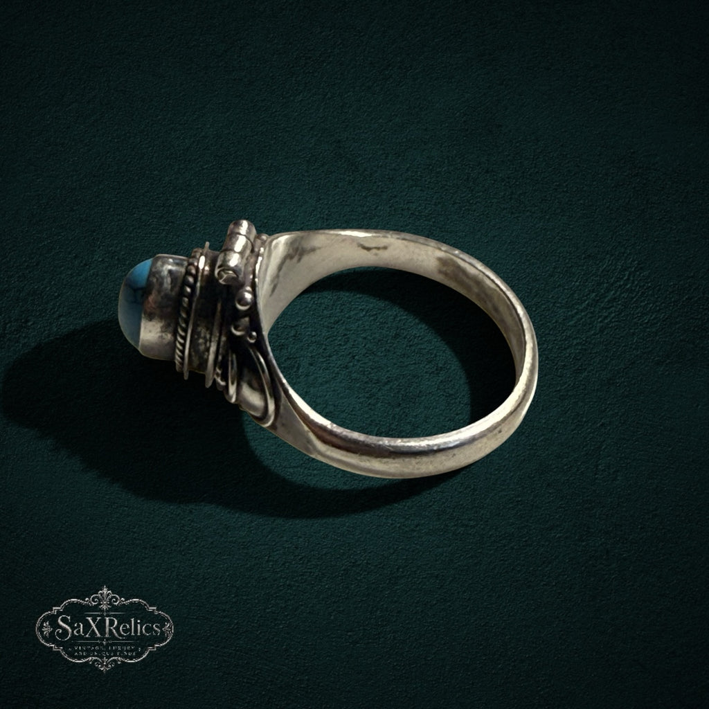 My Store SAXRelics vintage sterling silver poison ring with a hinged turquoise stone and intricate scrollwork band.