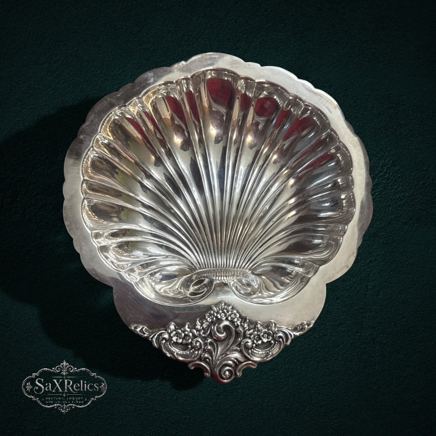 My Store vintage silver-plated scalloped shell serving dish with ornate floral detailing on a dark background.