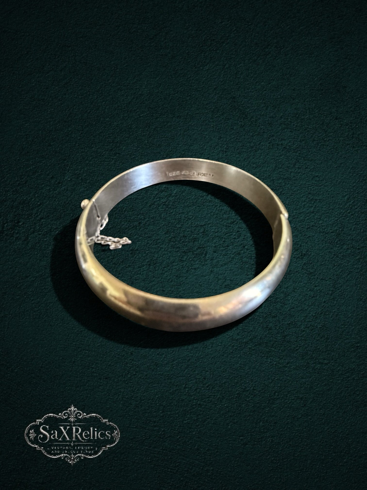 My Store vintage sterling silver hinged bangle bracelet with a polished finish and integrated safety chain.