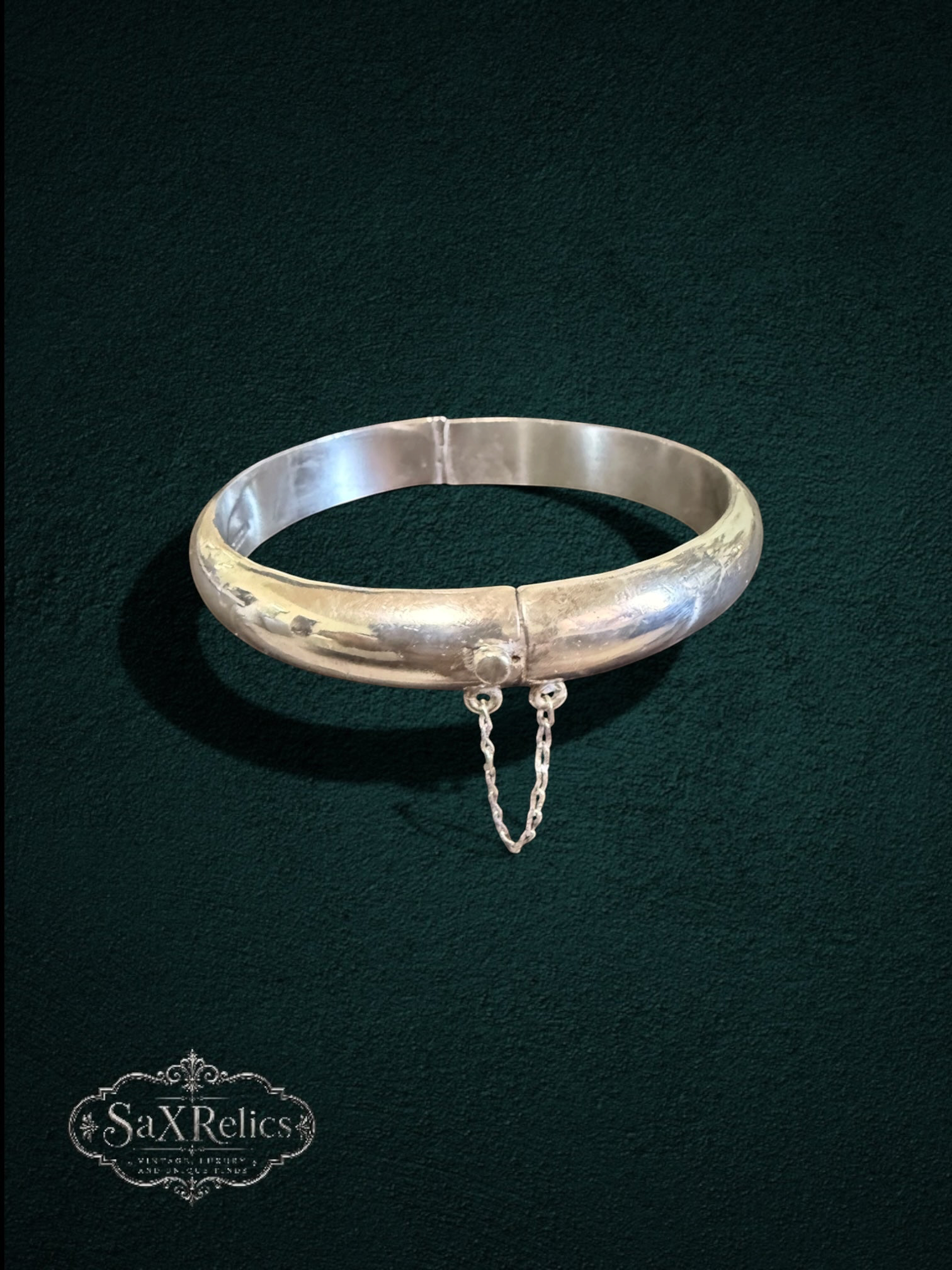 My Store vintage sterling silver hinged bangle bracelet with a polished finish and integrated safety chain