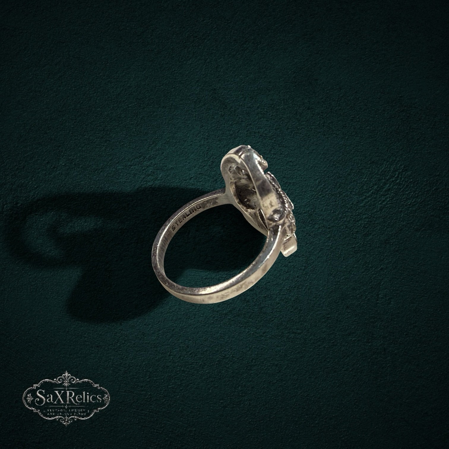 My Store vintage sterling silver ring with intricate filigree and marcasite stones, shown from a side angle.