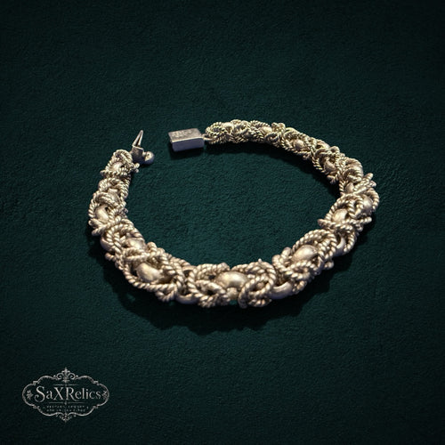 My Store vintage sterling silver bracelet featuring an intricate woven rope-link design on a dark textured background.