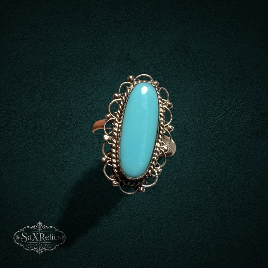 My Store SAXRelics vintage sterling silver ring with an elongated oval turquoise cabochon and intricate filigree detail.